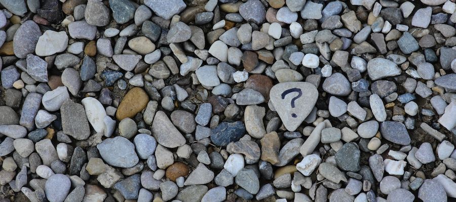 a bunch of rocks with one painted with a question mark.