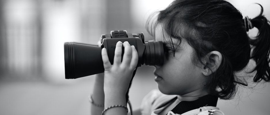 Little girl looking through binoculars.