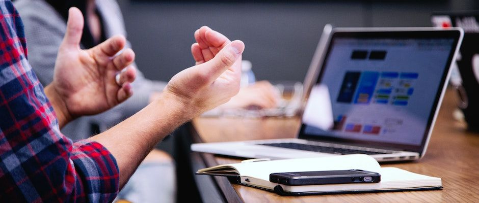 hands in front of a laptop in an asking a question gesture