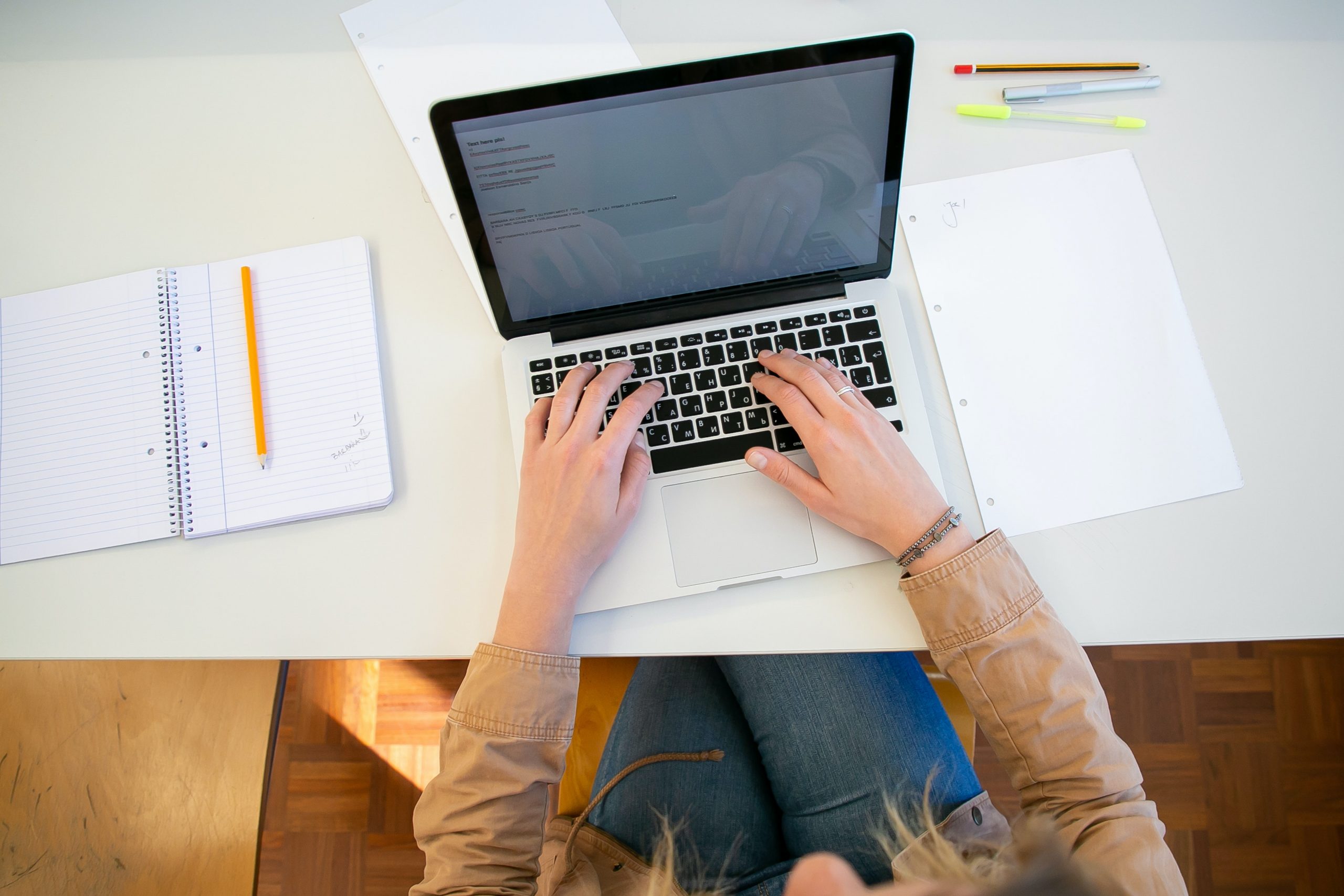 Hands typing on a laptop from overhead